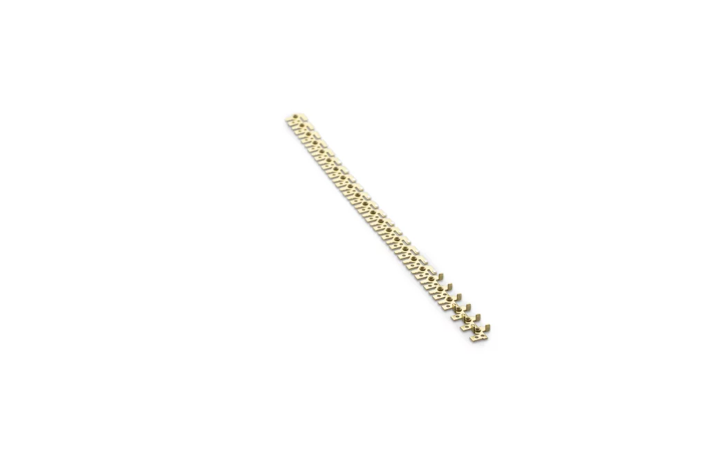 Ein von Fuchs Metalltechnik gefertigtes Armband aus Goldkette mit Karabinerverschluss ist diagonal auf einem weißen Hintergrund abgebildet, wobei sich „Technik trifft Handwerk“ in jedem Detail widerspiegelt.